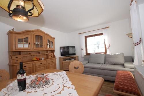 a living room with a couch and a table at Pfandlhof in Walchsee