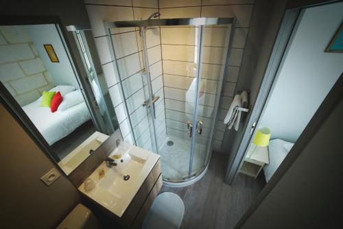 an overhead view of a bathroom with a shower and a sink at Hotel de la gare in Château-du-Loir