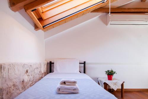 a bedroom with a bed with a towel on it at Sivros Stone Cottages in Sívros