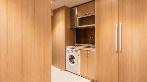 uma cozinha com uma máquina de lavar roupa e uma máquina de lavar roupa em First Stay Hotel em Seul