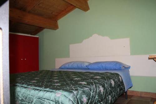 a bedroom with a bed with blue pillows on it at Casa D'arte in Tocco da Casauria