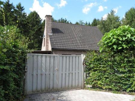 a white fence in front of a house at Stropershuisje in Stekene