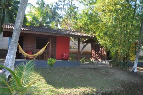 a small house with a hammock in front of it at Sitio Os Tres in Camaçari