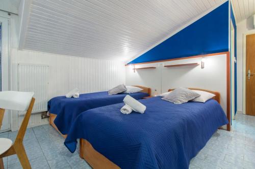 two beds in a room with blue sheets at Vila Marija in Skradin