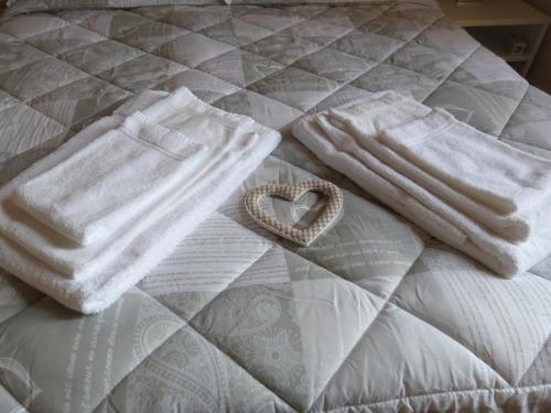a bed with white towels and a heart on it at Ca' da Valeria in Chiavari