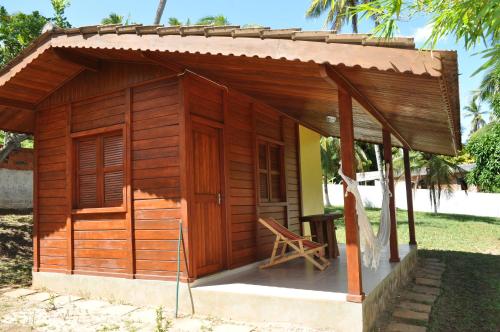 a small wooden house with a table and a chair at Sitio Os Tres in Camaçari