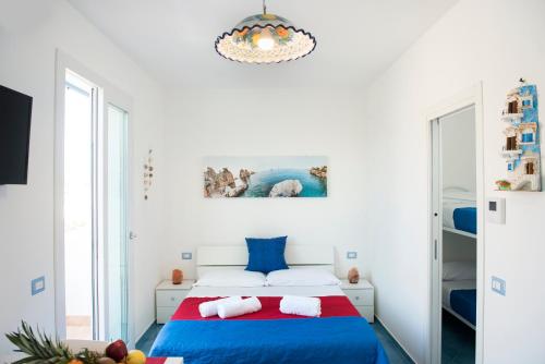 サン・ヴィート・ロ・カーポにあるAppartamento Giuliaのベッドルーム1室(ベッド1台、シャンデリア付)