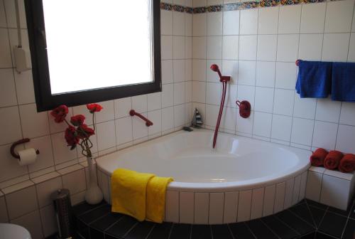 a bath tub in a bathroom with a window at Ferienwohnung Rosengarten in Osburg