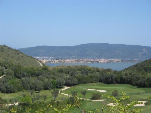 a view of a golf course with a lake at Country Relais La Mortella in Porto Ercole
