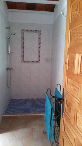 y baño con ducha y alfombra azul. en The Shed en Cehegín