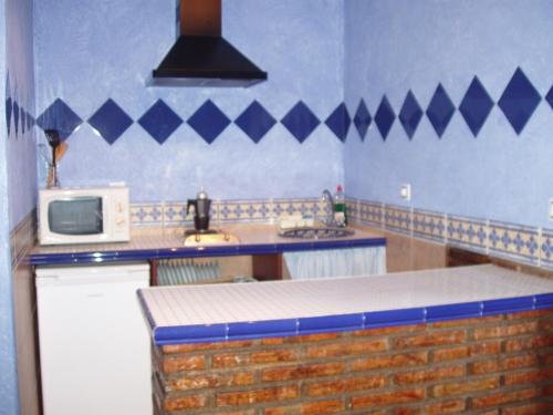 cocina con microondas y encimera en Cortijo los Llanos, en Luque