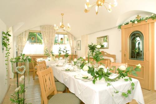 uma sala de jantar com uma mesa longa com flores sobre ela em Gasthof Feichter em Finkenstein