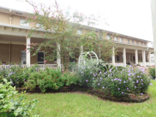 a garden in front of a building with flowers at Cassadaga Hotel and Spiritual Center in Cassadaga