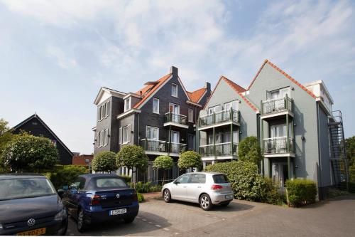 two cars parked in a parking lot in front of a building at Hotel In den Brouwery in Domburg