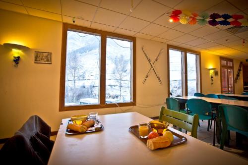 d'une salle à manger avec deux tables et de la nourriture. dans l'établissement Centre de Vacances Le Hameau Rollot, à Barèges