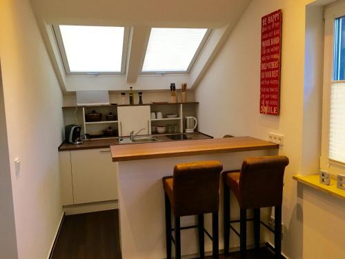a kitchen with a counter and two stools at a bar at Seaside-Townhouse in Timmendorfer Strand
