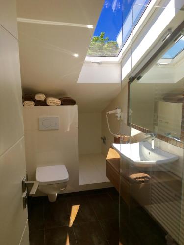 a bathroom with a toilet and a sink and a skylight at Seaside-Townhouse in Timmendorfer Strand