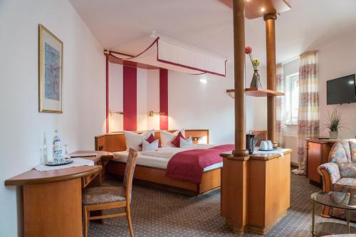Habitación de hotel con cama, mesa y sillas en Hotel Chalet en Bad Zwischenahn