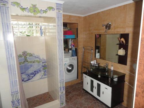 a bathroom with a sink and a washing machine at Casa do Rei in Furnas