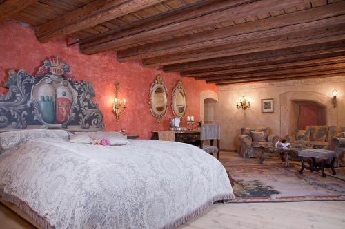 um quarto com uma grande cama branca e paredes vermelhas em Schloss Matzen em Reith im Alpbachtal