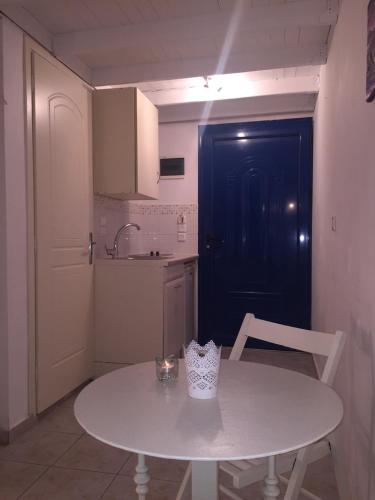 a small kitchen with a white table and a black door at Dreams Apartments - Katelios,Santa Barbara beach in Katelios