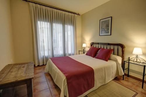a bedroom with a bed and a large window at Casa El Sastre III in Beceite