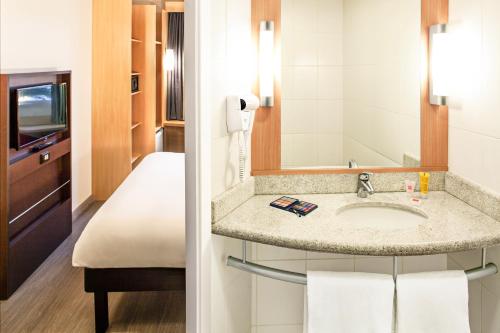 a bathroom with a sink and a mirror at ibis Rio de Janeiro Parque Olimpico in Rio de Janeiro