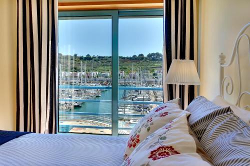 a bedroom with a large window with a view of a marina at Marina Coast Residence in Albufeira
