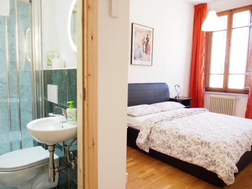 a bedroom with a bed and a sink and a shower at Eco Pisa Tower Guesthouse in Pisa