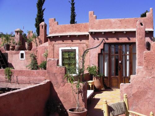 een rood bakstenen huis met een deur en een patio bij Riad Cascades d'Ouzoud in Ouzoud