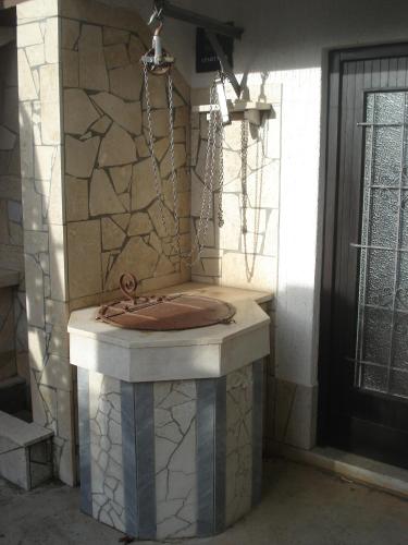 a stone fountain in the corner of a building at Apartmani Tijano in Krnica