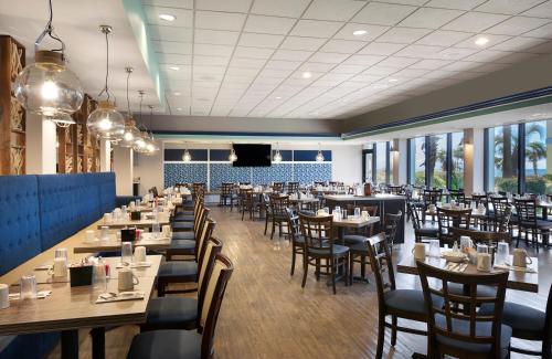 a dining room with tables and chairs and windows at Compass Cove in Myrtle Beach