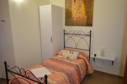 a bedroom with a bed and a painting on the wall at B&B Il Vicoletto in LʼAquila