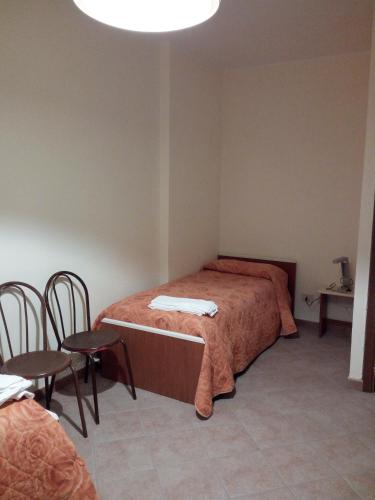 a bedroom with two beds and a table and chairs at Albergo Ristorante Pizzeria Del Viale in Palazzo Adriano