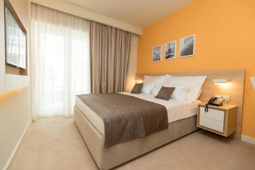 a hotel room with a bed and a window at Hotel Crikvenica in Crikvenica