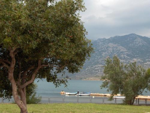 a boat on a lake with mountains in the background at Bed & Breakfast Dora in Rovanjska