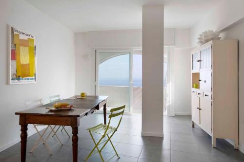 una sala da pranzo con tavolo, sedie e finestra di Le calandre a Ventimiglia