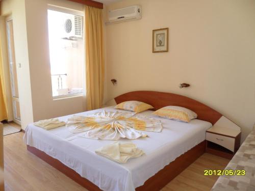 a bedroom with a bed with towels on it at Guest House Hetodon in Sozopol