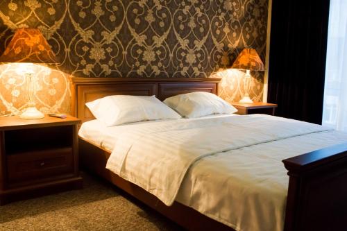 a bedroom with a large bed with two lamps on it at Alir in Zhytomyr