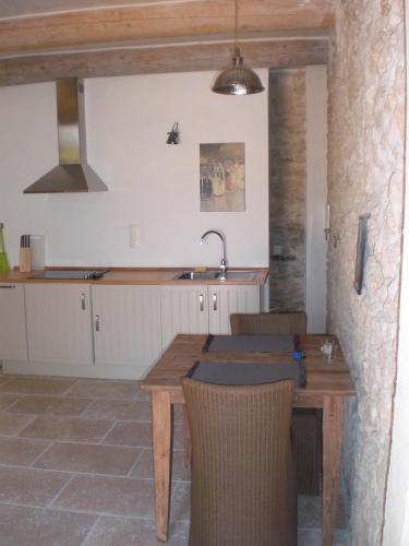 - une cuisine avec une table en bois et un évier dans l'établissement Château de Peyrolles, à Apt