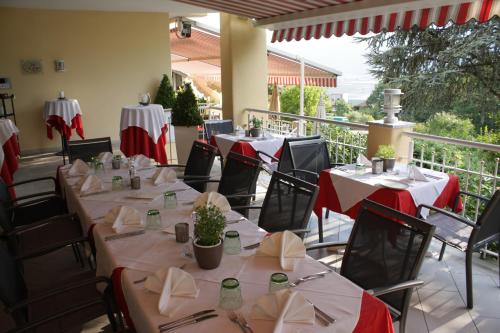a restaurant with tables and chairs with red and white tablecloths at Gartenresidence Stephanie by Hotel Rotwand in Laives