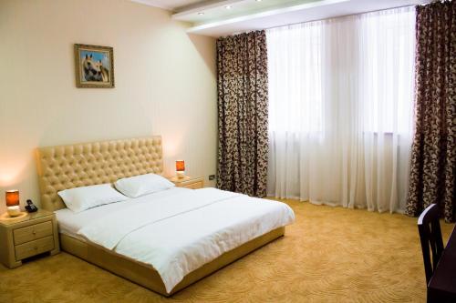 a bedroom with a bed and a large window at Alir in Zhytomyr