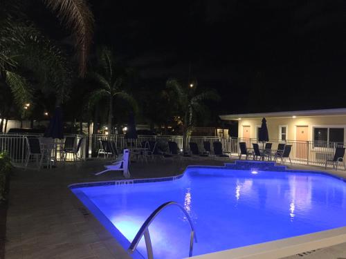 a swimming pool at night with tables and chairs at Curtis Inn & Suites in Hollywood