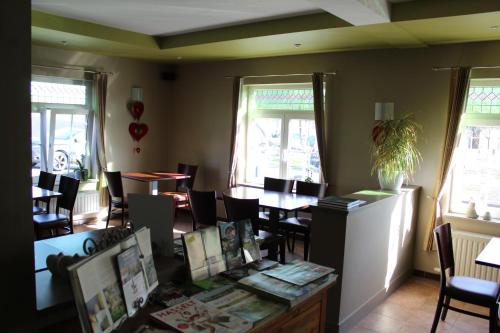 a dining room with tables and chairs and windows at B&B De Vroling in Wellen