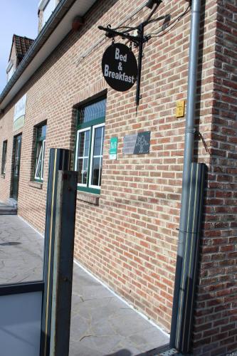 a sign on the side of a brick building at B&B De Vroling in Wellen