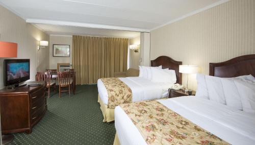 a hotel room with two beds and a television at The Spinnaker in Ocean City