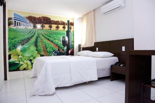 een slaapkamer met een bed en een schilderij van een veld bij JB Hotel in Petrolina