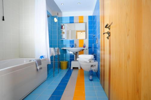 MaroulásにあるKivotos Villaのバスルーム(バスタブ、トイレ、シンク付)