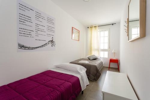 een slaapkamer met 2 bedden en een bord aan de muur bij PASACALLES Home by Cadiz4Rentals in Cádiz