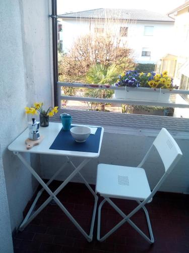 une table et une chaise devant une fenêtre dans l'établissement Ichnussa, à Udine